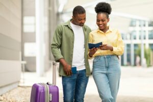 Happy African American Travelers Couple Holding Passports Standing Near Airport