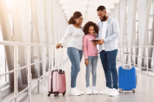 Happy excited black family traveling, looking at documents in airport
