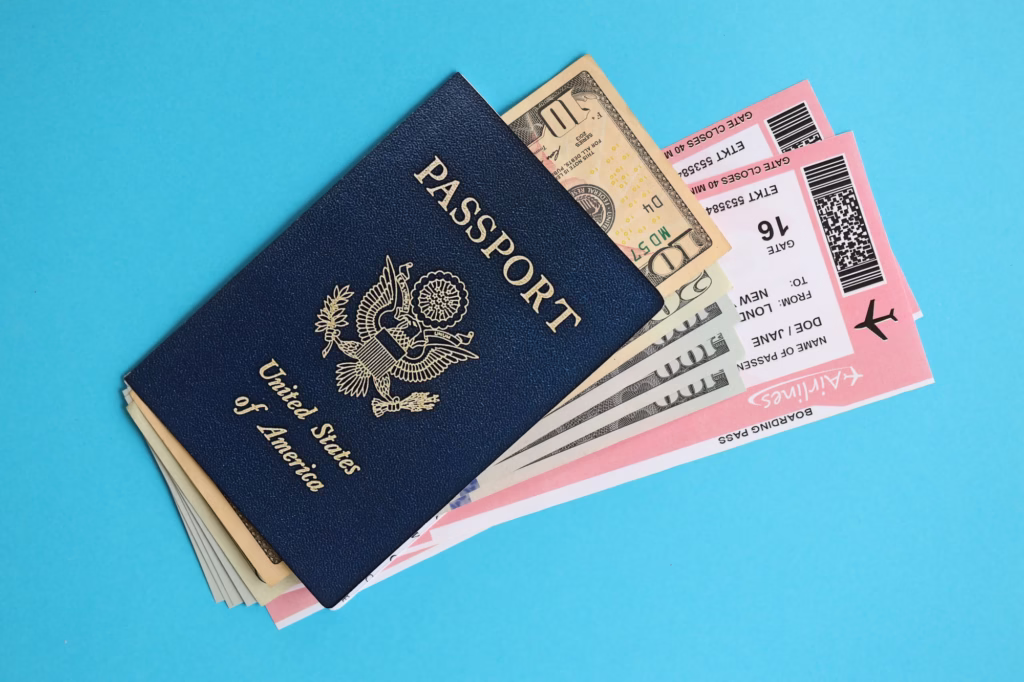 Blue United States of America passport with money and airline tickets on blue background