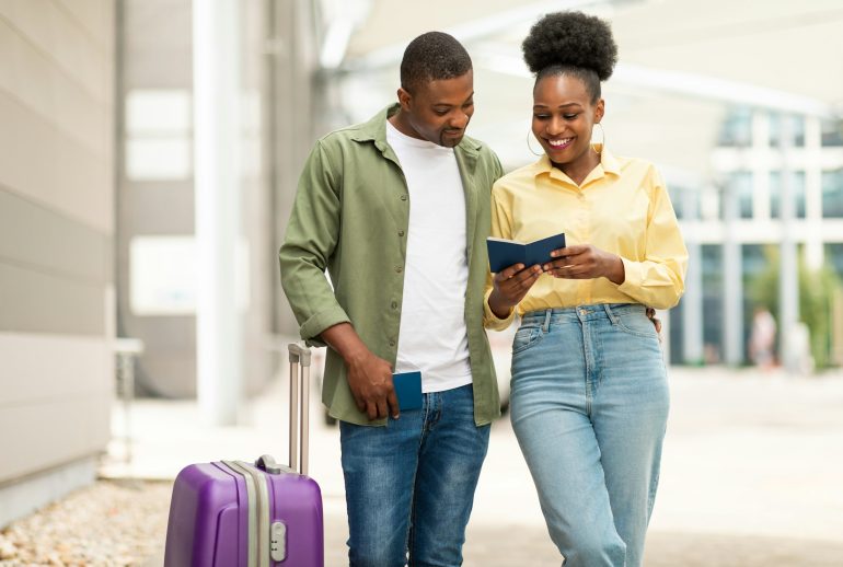 Happy African American Travelers Couple Holding Passports Standing Near Airport